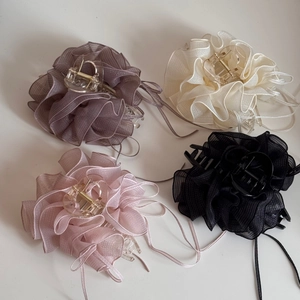 Vue détaillée de quatre pinces à cheveux à fleurs plissées en plusieurs couleurs douces