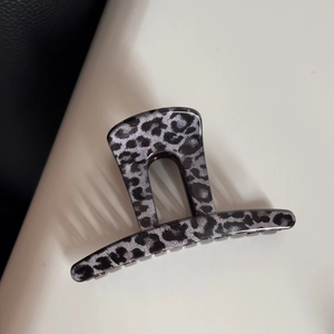 Detail view of large leopard print hair claw clip with dark grey and black pattern