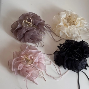 Vue à plat de quatre pinces à cheveux en organza de couleurs violet, blanc, rose et noir