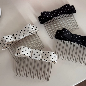 Detailed view of black and white polka dot bow hair combs with silver metal teeth