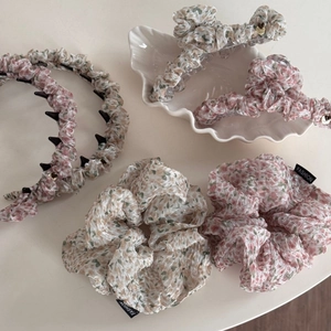 Detailed close-up of floral hair claw clips and scrunchies with handmade metal tag detail