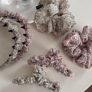 Flat lay of floral hair accessory set featuring scrunchie, headband and hair claw clips