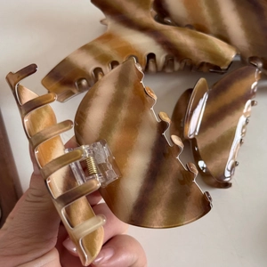 Detail of tortoise shell patterned hair claw clips with metal spring and striped texture