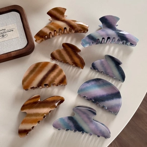 Macro shot of colorful twill acetate hair claws in brown and blue gradient finishes
