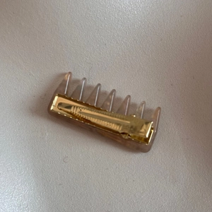 Detail view of gold metal teeth and brown resin finish on vintage rhinestone hair clip