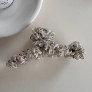 Detail of floral fabric hair claw clip with golden handmade heart charm accessory