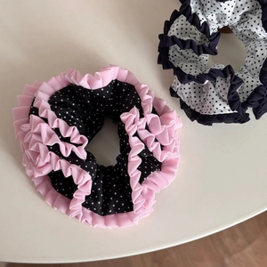 Close-up of pleated polka dot lace scrunchies with pink and navy chiffon ruffles