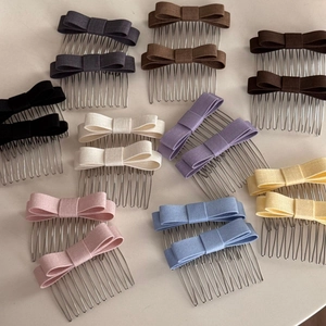 Collection of nine colorful fabric bow hair combs showing texture and metal teeth