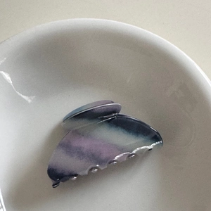 Detailed close-up of marble pattern hair claw clip with purple and blue gradient textures