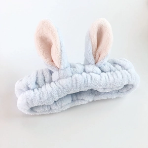 Close-up of soft blue plush bunny ear headband made of coral fleece for facial cleansing