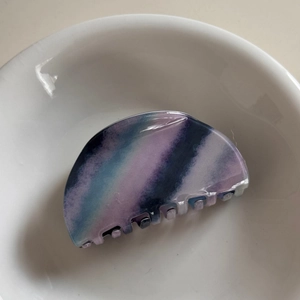 Detailed macro view of a colorful gradient claw clip with secure fixing teeth for hairstyling