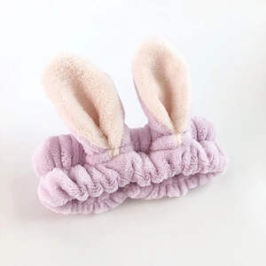 Close-up of soft purple plush rabbit ear headband with elastic pleated texture detail