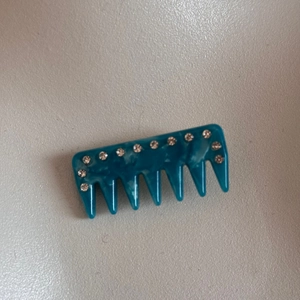 Detailed macro view of peacock blue marble texture hair comb with sparkling rhinestones