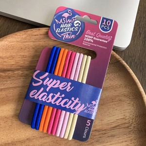Macro view of 10pcs colorful thin hair elastics in high elasticity on a wooden tray
