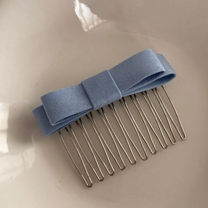 Close-up of a blue fabric bow hair comb with 10-tooth silver metal U-shaped design