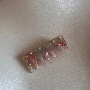Close-up of pink and grey stone texture hair comb with eleven sparkling rhinestones