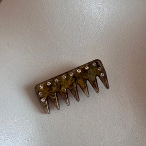 Detail of vintage tortoiseshell hair comb with white rhinestones and a polished finish