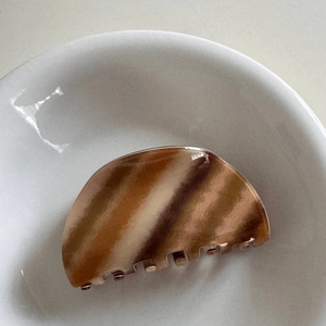 Detail view of a vintage tortoise shell hair claw with diagonal brown and beige patterns