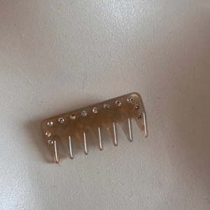 Detailed macro view of amber translucent resin hair comb with sparkling rhinestones decoration