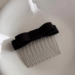 Detail of multi-layered black fabric bow hair comb with thirteen silver metal prongs
