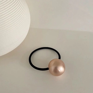 Macro view of high-elastic black hair tie with a rose gold brushed metal spherical bead