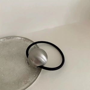 Minimalist silver metal ball hair tie with matte brushed texture and black elastic band