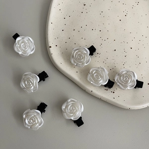 Détail de six pinces à cheveux roses blanches nacrées sur une assiette en céramique