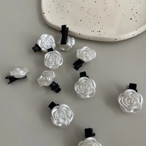 Détail de barrettes roses blanches en résine nacrée avec base en plastique noir