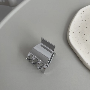 Close-up of a small polished silver metal hair claw clip with a secure spring design