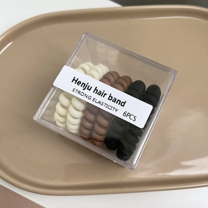 Lot de 6 chouchous spirales mats en noir, marron et blanc dans une boîte carrée claire