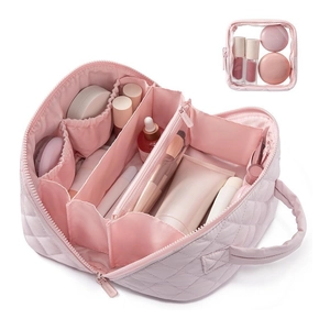 Detailed interior of pink quilted nylon makeup bag with partitions and brush slots