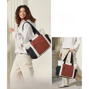 Detail view of a quilted tricolor tote bag with side drawstring and front zipper pockets
