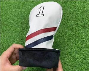 Dettaglio del coprimazza da golf in pelle bianca con fodera e ricamo numero 1
