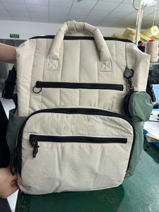 Quilted beige and olive diaper backpack with multiple pockets and small coin purse