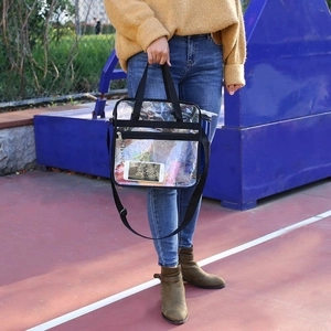 Detail of transparent PVC tote bag with black nylon straps and front zipper pocket
