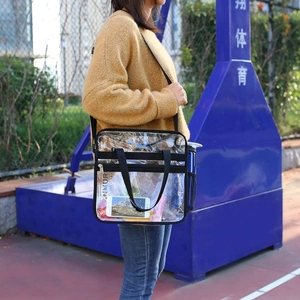 Detailed view of clear PVC tote bag showing side mesh pocket and interior storage capacity