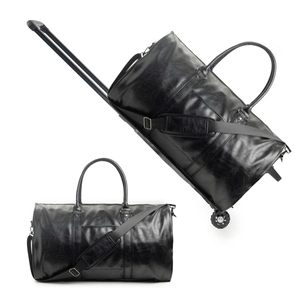 Detail of black leather travel bag showing retractable trolley handle and silent wheels