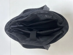 Internal view of black puffer tote featuring a padded laptop sleeve and multi-pocket storage