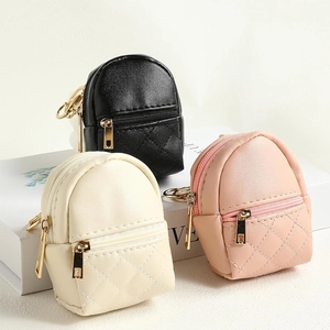 Detailed view of mini PU leather quilted backpacks in black, cream, and pink with gold zippers