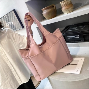 Détail d'un grand sac de voyage rose en nylon avec poches avant et grande capacité