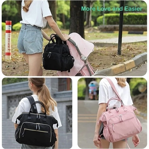 Close-up of pink and black baby diaper bags hanging on a stroller for easy storage