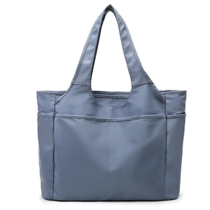 Détail frontal du grand sac fourre-tout gris-bleu avec poches avant plaquées