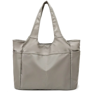 Détail d'un grand sac de voyage gris avec de multiples poches et des poignées durables