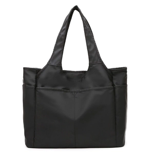 Détail du grand sac cabas noir en nylon avec coutures en V et poche frontale pratique