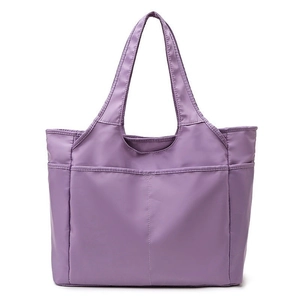 Détail du sac de voyage en nylon violet montrant les poches et le tissu imperméable