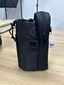 Detail view of black nylon tactical water bottle pouch with drawstring and zipper pocket