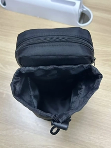 Detailed close-up of a black nylon water bottle pouch with zipper and drawstring top