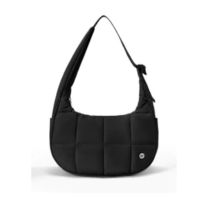 Gros plan sur le sac en nylon noir matelassé avec logo métallique et sangle ajustable
