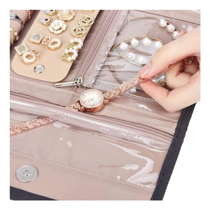 Pink faux suede jewelry travel roll with multi-layered compartments and zip pockets