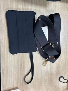 Detalle del bolso de viaje acolchado negro con cremalleras doradas y correa de hombro